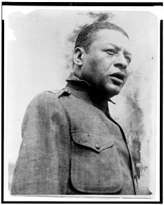 Bert Williams, head-and-shoulders portrait, standing, facing right, singing a psalm at the first regimental open air service for the 15th Regiment of the New York National Guard, held in LCCN96521643