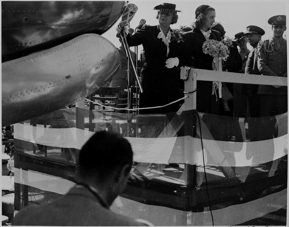 Bess Truman christens an airplane with a bottle of champagne. Margaret Truman is beside her. - NARA - 199103