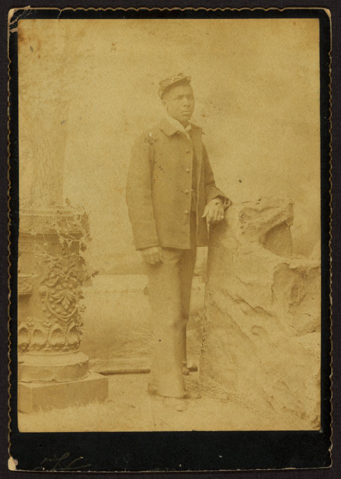 Buffalo soldier, full-length portrait, standing, crossed rifles on kepi, ring on pinky finger LCCN2010645148