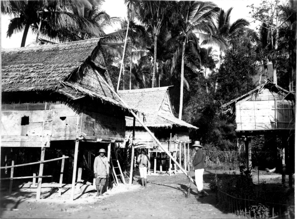 Byscen, t.v. två bostadshus, t.h. en risbod. Doohian. Indonesien - SMVK - 000188