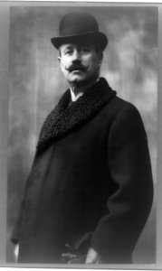 Cleofonte Campanini, half-length portrait, standing, facing front, wearing overcoat and hat LCCN93511632