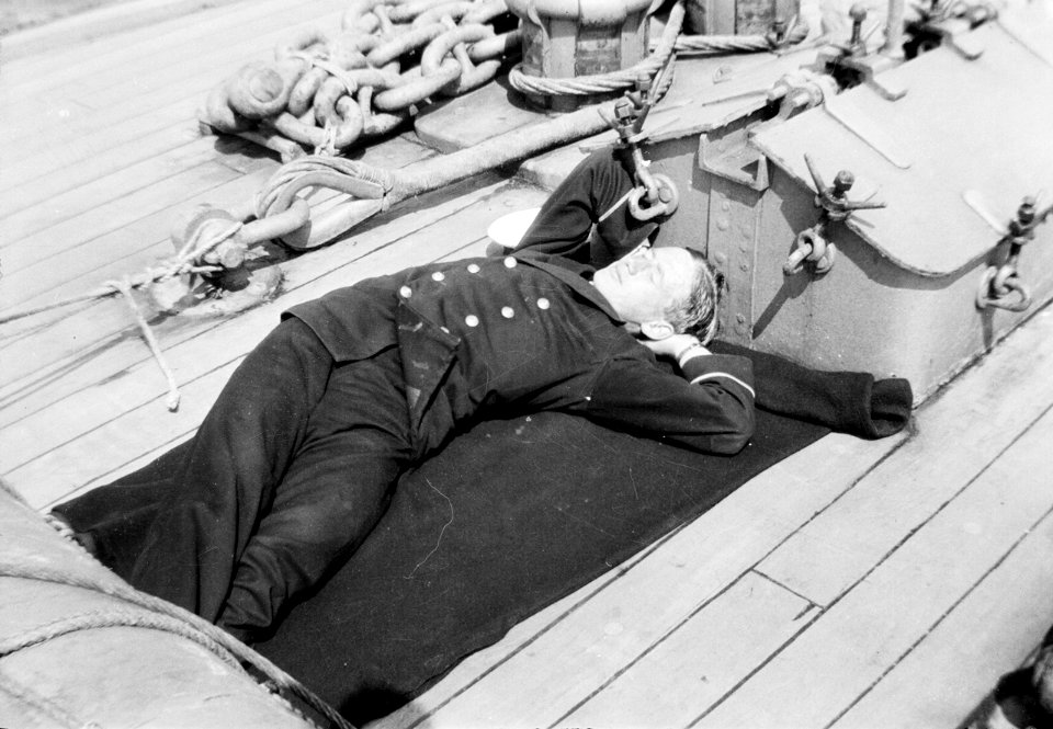 Clerk R. R. Wallace asleep on the quarterdeck of HMS 'Aurora' (1913). RMG N22880