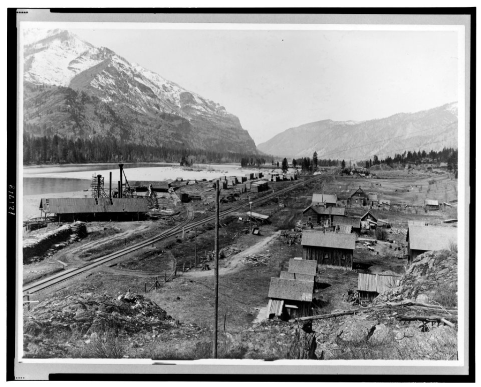 Bird's-eye view of Eddy, Montana, showing buildings, railroad tracks along river, and snow-capped mountains in background LCCN98519298
