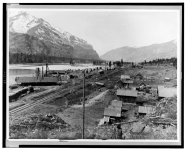 Bird's-eye view of Eddy, Montana, showing buildings, railroad tracks along river, and snow-capped mountains in background LCCN98519298