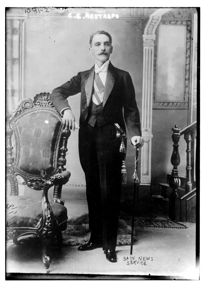 C.E. Restrepo posing next to chair, with cane LCCN2014685351