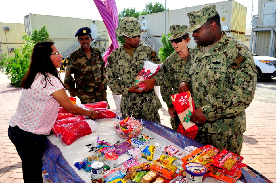 Camp Lemonnier religious programs specialists hand out Christmas gifts 141208-N-RY232-024