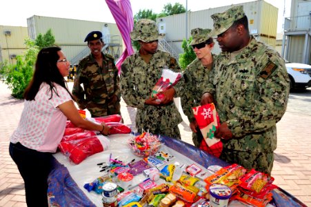 Camp Lemonnier religious programs specialists hand out Christmas gifts 141208-N-RY232-024