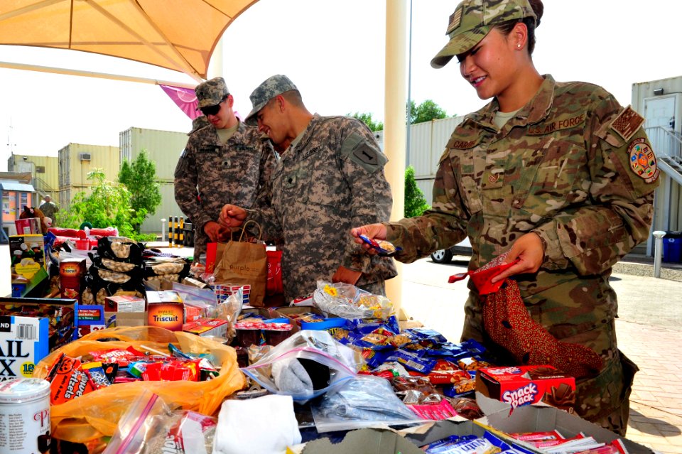 Camp Lemonnier religious programs specialists hand out Christmas gifts 141208-N-RY232-008
