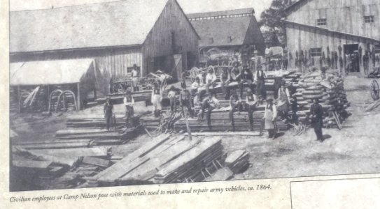 Camp Nelson civilian employees pose with materials to make and repair military vehicles