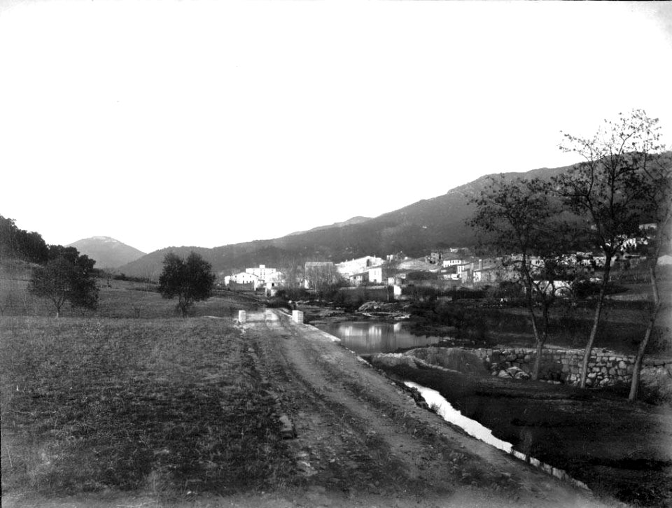 Camí a la riba d'un riu amb la Junquera entre muntanyes al fons