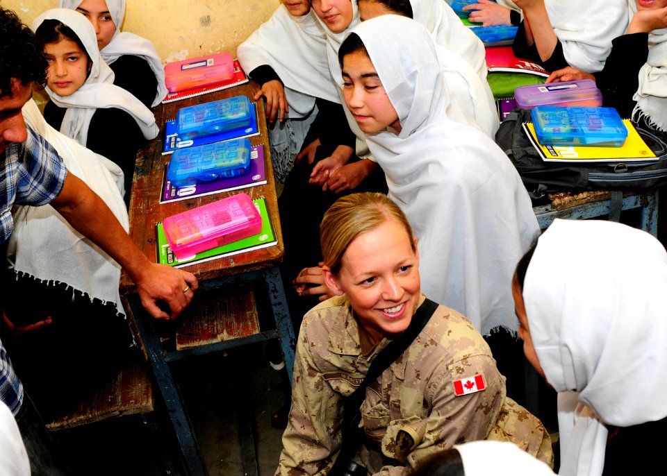 Canadian Lt. Jenna Martin, center, speaks with Afghan students after Afghan National Civil Order Police and Coalition advisors handed out donated school supplies. (4678254750)