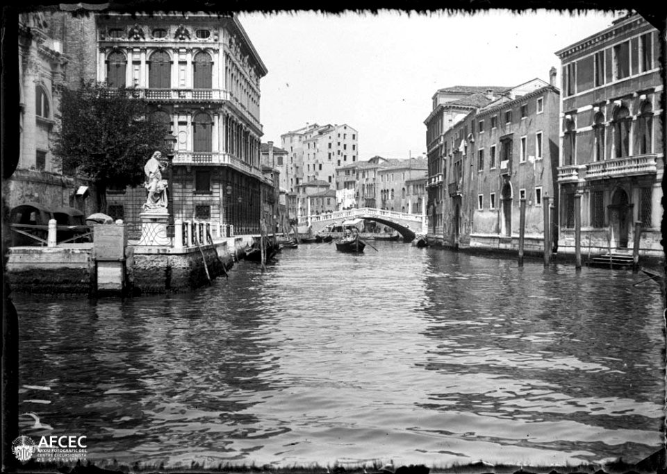 Canal de Venècia amb una barca i un pont al fons