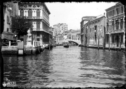 Canal de Venècia amb una barca i un pont al fons