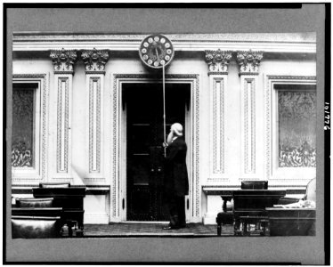 Capt. Isaac Bassett, employee of U.S. Senate for over 60 years, turning back the hands of the Senate clock at close of a session of Congress) - Harry O. Hall LCCN90713442
