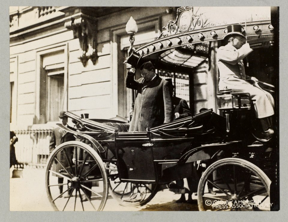 Col. Theodore Roosevelt standing in carriage and saluting crowd when leaving The Hague from Des Indias Hotel LCCN91789200