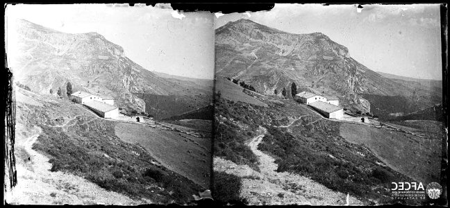 Coll del terme d'Odèn amb una masia en primer terme i un cim al fons