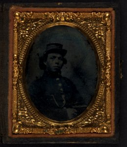 Black soldier seated with pistol in hand, watch chain in pocket LCCN2002719396