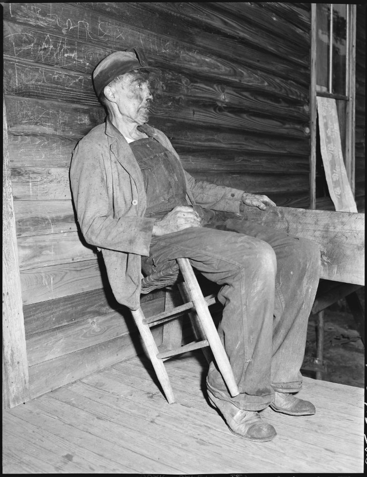 Blaine Sergent, coal loader, rests briefly on his front porch before taking his bath after the day's work, he had... - NARA - 541289