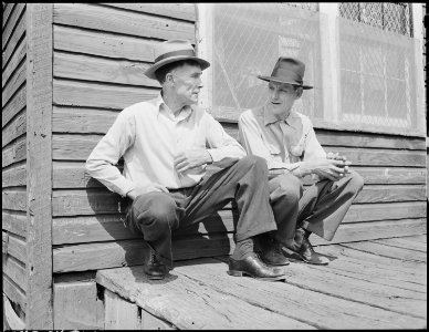 Blaine Sergent, left, talks with a fellow miner in the front porch of the company store on Saturday morning. Talking... - NARA - 541317