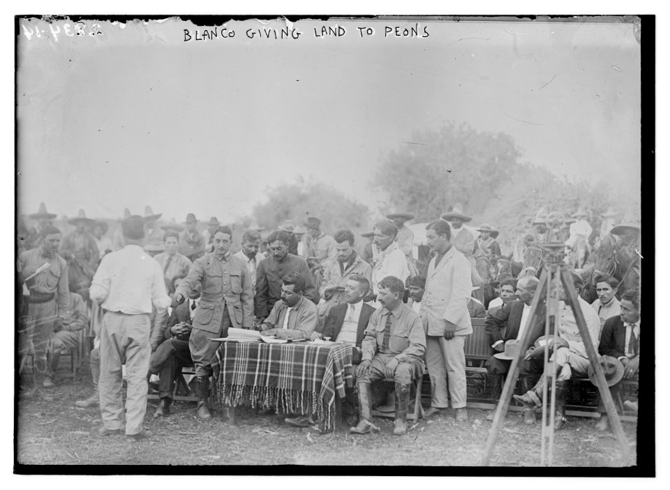 Blanco giving land to Peons at table in field LCCN2014694304