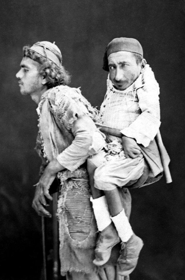 Blind man carrying a paralysed man