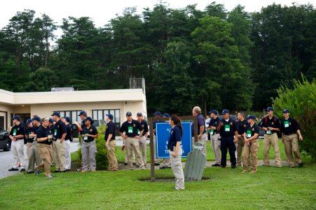 Blue-shirted law enforcement explorers standing in the grass photo