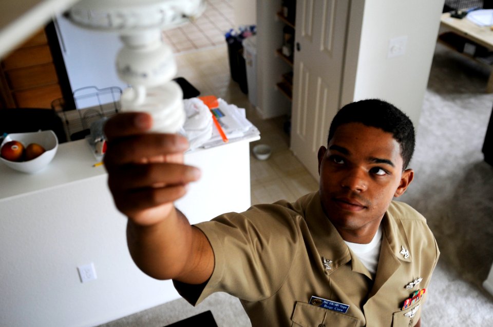 Boatswain's Mate 2nd Class Kerik Vargas switches his lights to high efficient light bulbs