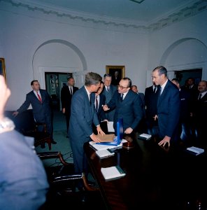 Carlos Manuel Muñiz presents a gift of a vicuña poncho to President Kennedy