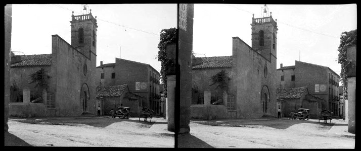Carrer d'un poble amb un cotxe i un carro davant l'església