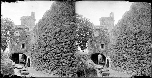 Carrer amb part de la muralla i una torre i alguna gent a la Vila Vella de Tossa de Mar