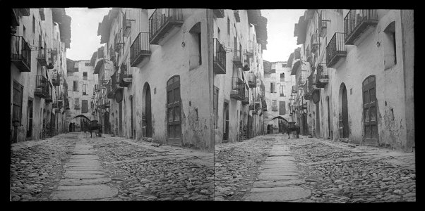 Carrer de Tremp amb un arc al fons i un cavall