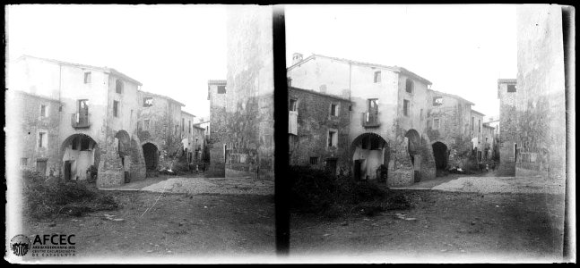 Carrer de Montagut amb porxos i un grup de gent al fons