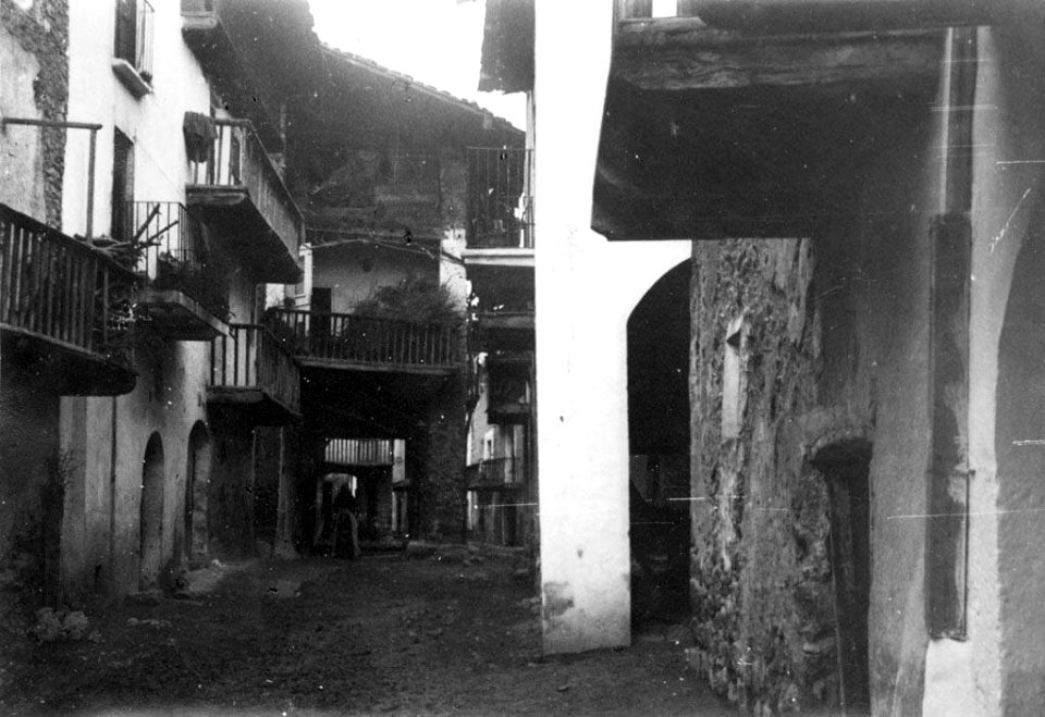 Carrer parcialment cobert amb porxos i una dona