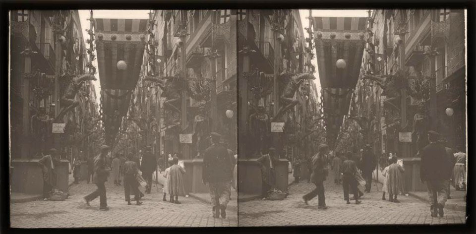 Carrer engalanat per les festes de la Mercè amb gent passejant