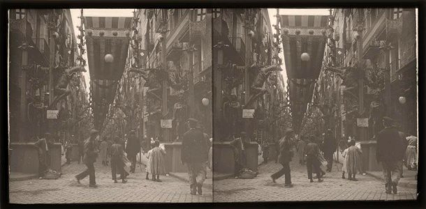 Carrer engalanat per les festes de la Mercè amb gent passejant