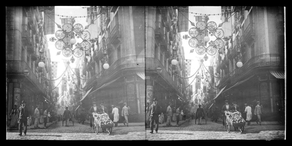 Carrer Ferran engalanat per les festes de la Mercè i gent passejant