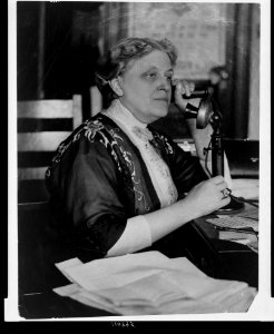 Carrie Chapman Catt, half-length portrait, seated, facing left, on telephone LCCN94506343