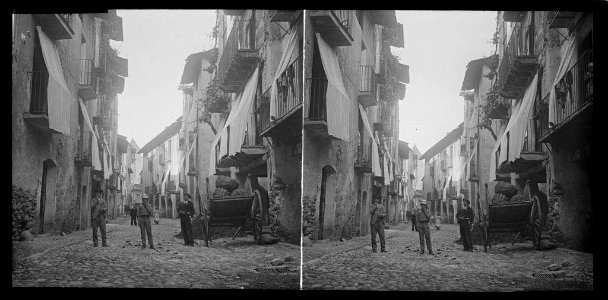 Carro , pregoners i gent en un carrer de la Seu d'Urgell