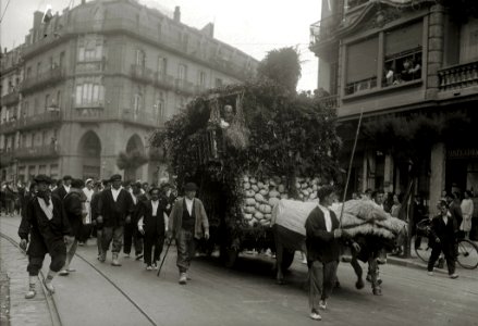 Carroza tirada por bueyes representando una borda con una comparsa de personas vestidas de caseros, desfilando por una calle de San Sebastián durante unas 'Fiestas Euskaras' (1 de 2) - Fondo Car-Kutxa Fototeka
