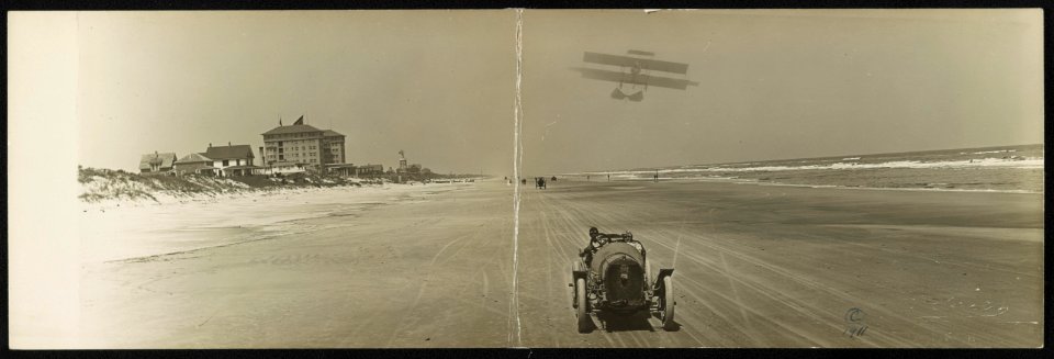 Cars on beach with airplane overhead and Clarendon Hotel in background, Seabreeze, Daytona Beach, Florida LCCN2013646915