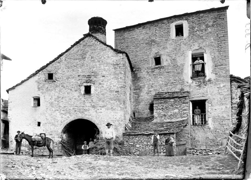 Casa de la Torre al poble de Buisán, amb gent i un cavall al davant