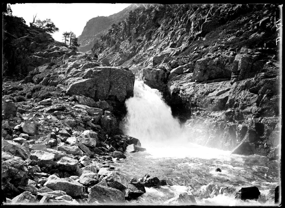 Cascada del barranc de Respomuso en una vall pedregosa amb una mica de vegetació