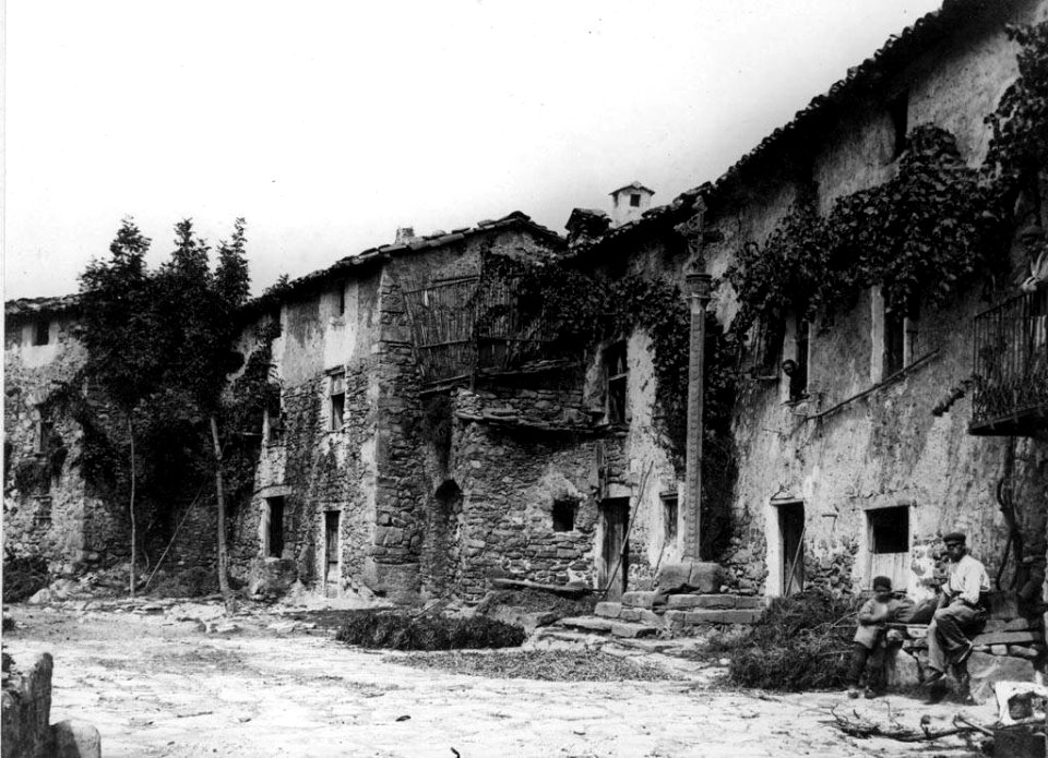 Cases al veïnat de la Creu de Campdevànol, a la dreta dos homes i creu