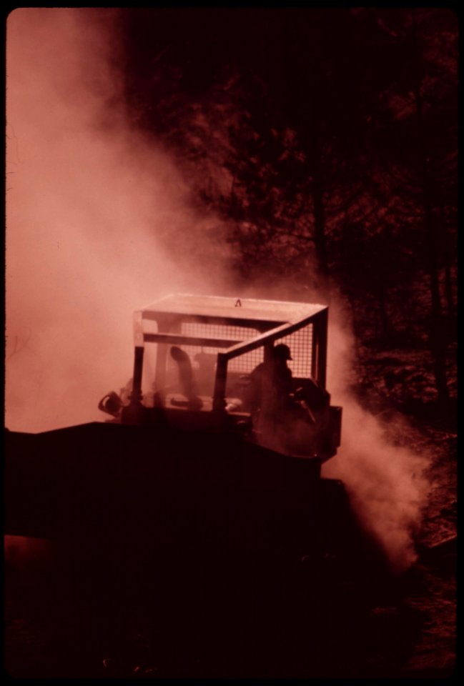 Caterpillars-work-in-dust-and-soot-hauling-logs-to-landing-area-where-they-will-be-loaded-onto-trucks-september-1973 7007022326 o