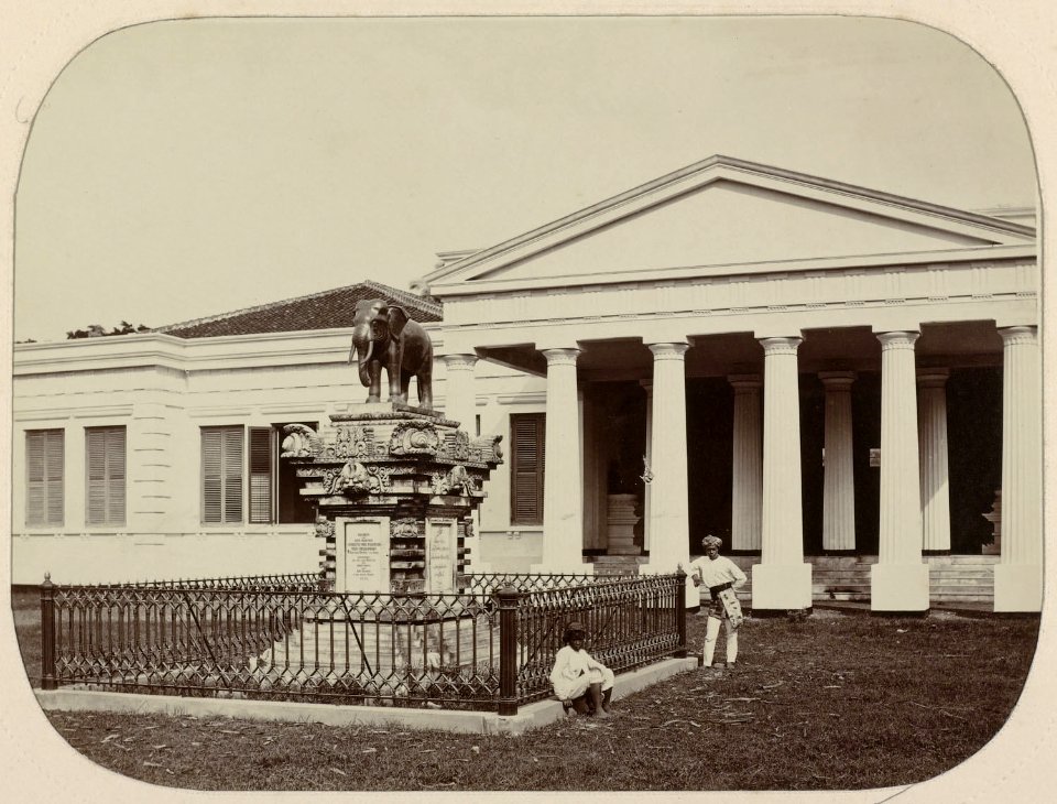 Collectie NMvWereldculturen, RV-A111-3-26, Foto, 'Museum in Batavia met tegenover de ingang een bronzen olifant, een geschenk van de koning van Siam', fotograaf Woodbury & Page, 1874-1875