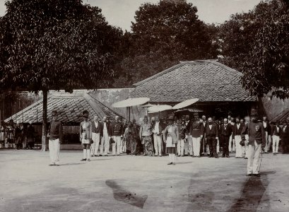 Collectie NMvWereldculturen, RV-A142-1-12, Foto, 'Groepsportret van gezelschap in de Kraton van Yogyakarta met onder de pajung de Sultan tijdens de Garebeg-feesten', fotograaf K. (Kassian) Céphas, ca. 1885