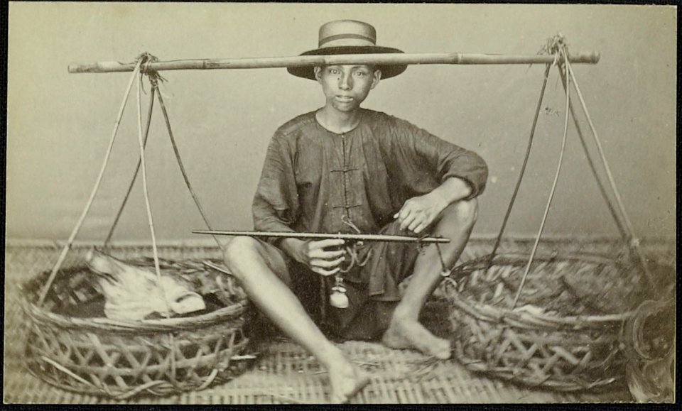Collectie NMvWereldculturen, RV-A39-101, Foto - carte-de-visite, 'Javaans-Chinese varkensslager zittend bij manden met handelswaar', fotograaf Woodbury & Page, 1875