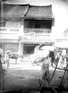 Collectie NMvWereldculturen, TM-10024625, Glasnegatief, 'Het lossen van een kar in de Chinese wijk in de benedenstad van Batavia', fotograaf onbekend, 1900-1907