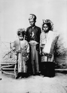 Collectie NMvWereldculturen, TM-60022831, Foto- 'Studioportret van een man, een vrouw en een kind uit Siloengkang in adatkleding', fotograaf C.B. Nieuwenhuis, 1892-1905