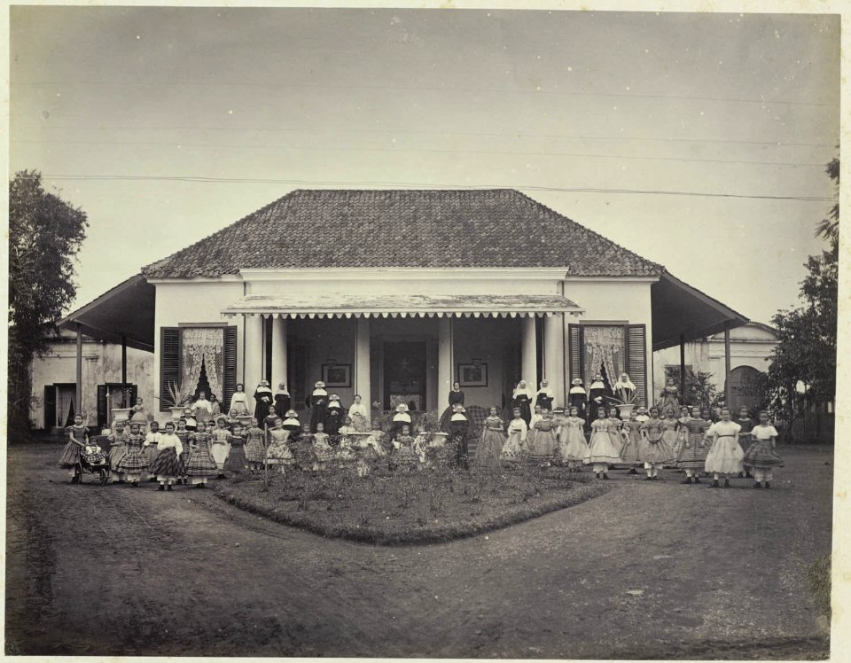 Collectie NMvWereldculturen, RV-A42-1-27, Foto, 'Onderkomen en school van de religieuze zusters Ursilinen in Batavia met bewoners en schoolkinderen', fotograaf Woodbury & Page, ca. 1875